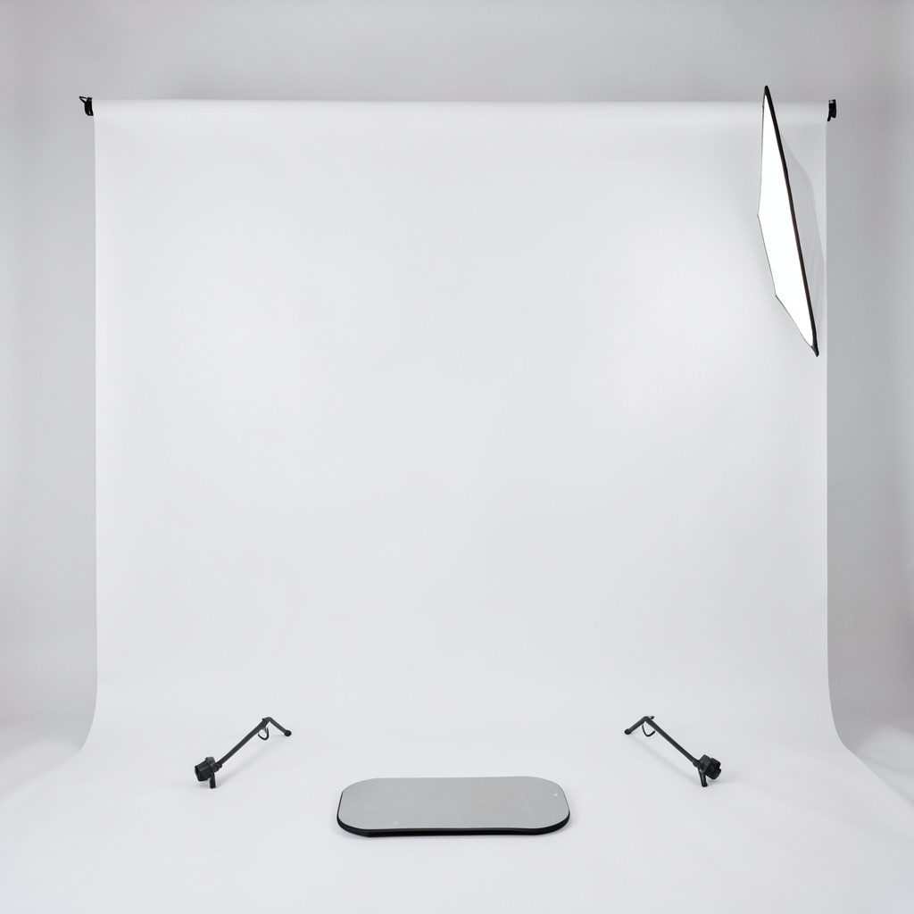 Studio banner image of a small desktop CNC mill with metal column and spindle, neutral light grey seamless backdrop, crisp technical product photography