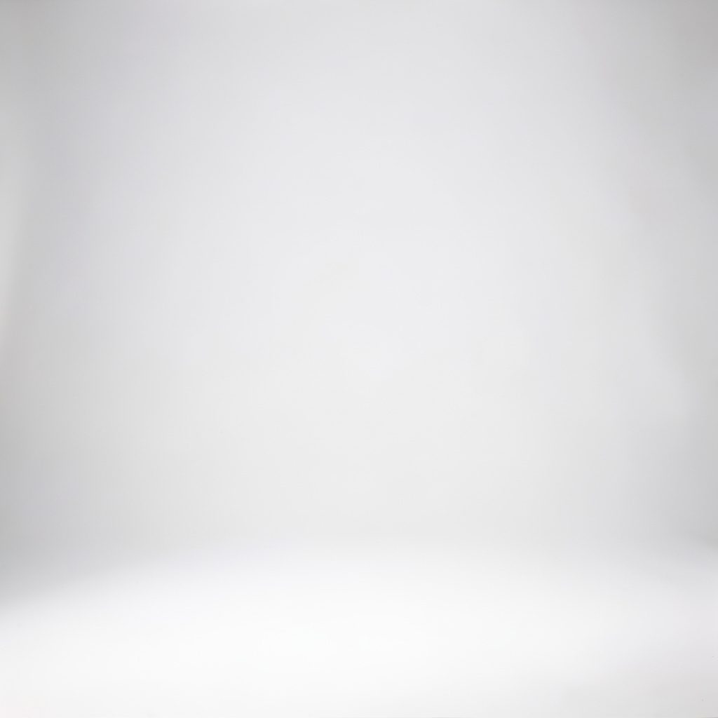 Studio photograph on a seamless light grey backdrop showing a compact benchtop CNC router work area, clean and neutral lighting